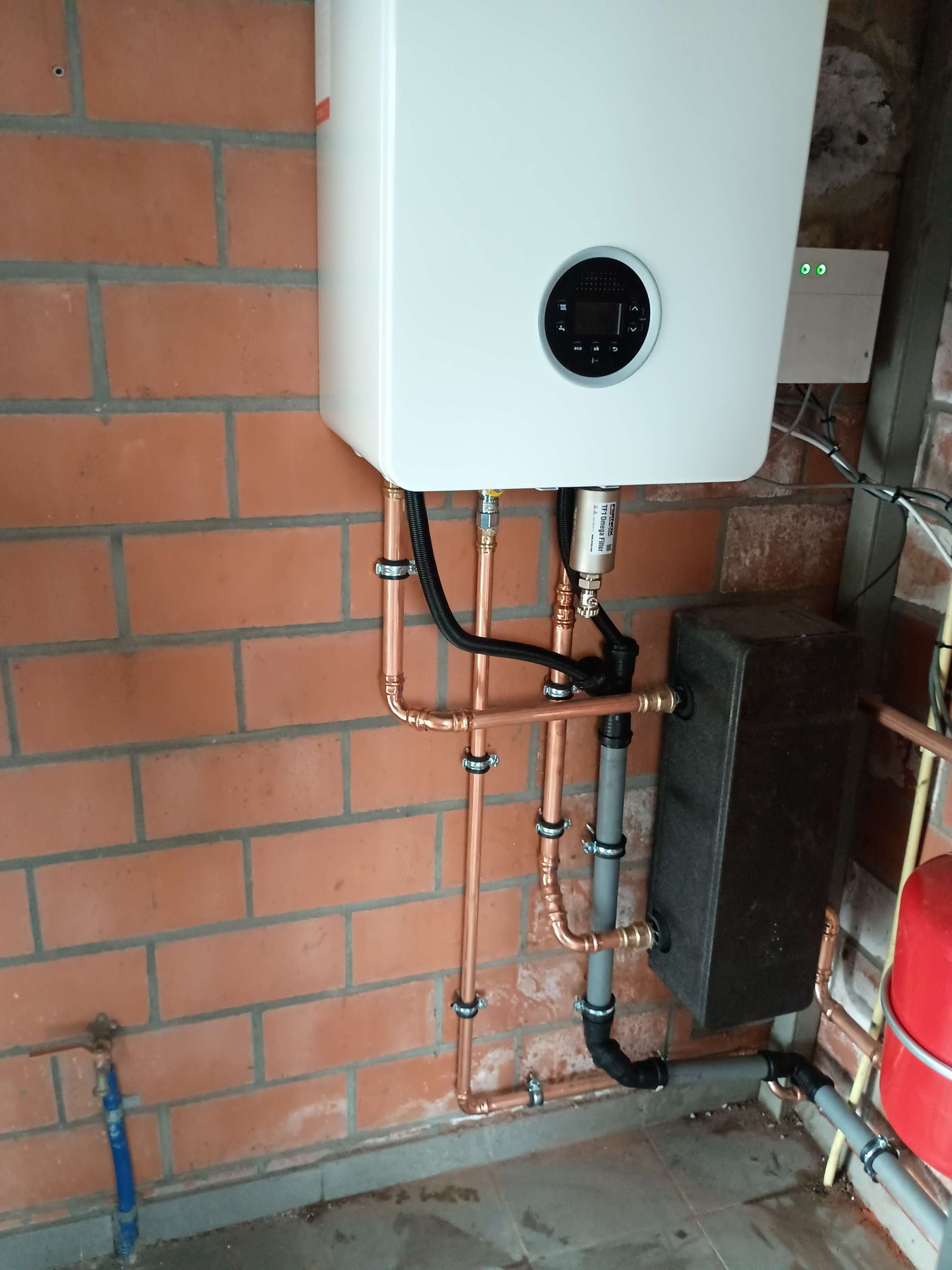 Aansluitingen en magneetfilter onder de Bosch-wandketel in Oostkamp